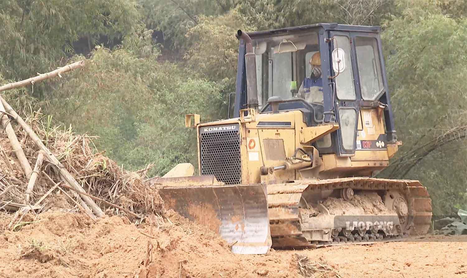 Công nhân thi công bóc tách lớp đất hữu cơ và thảm thực vật trên bề mặt các quả đồi.